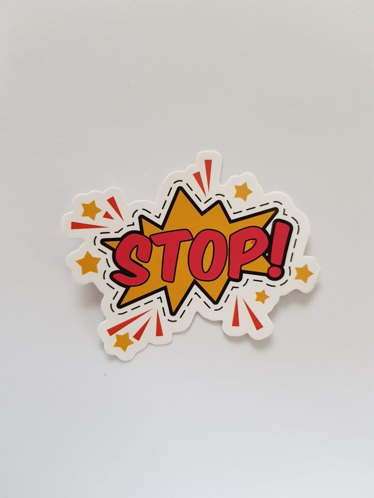 Bright and colorful sticker design featuring a comic-style 'Stop!' sign on a gray background.