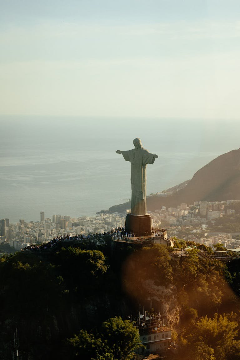 Majestic aerial view of Christ the Redeemer statue overlooking Rio de Janeiro at sunset.