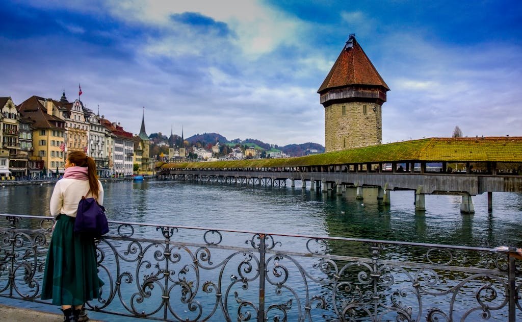 Traveler admires Chapel Bridge and Water Tower in Lucerne, Switzerland.